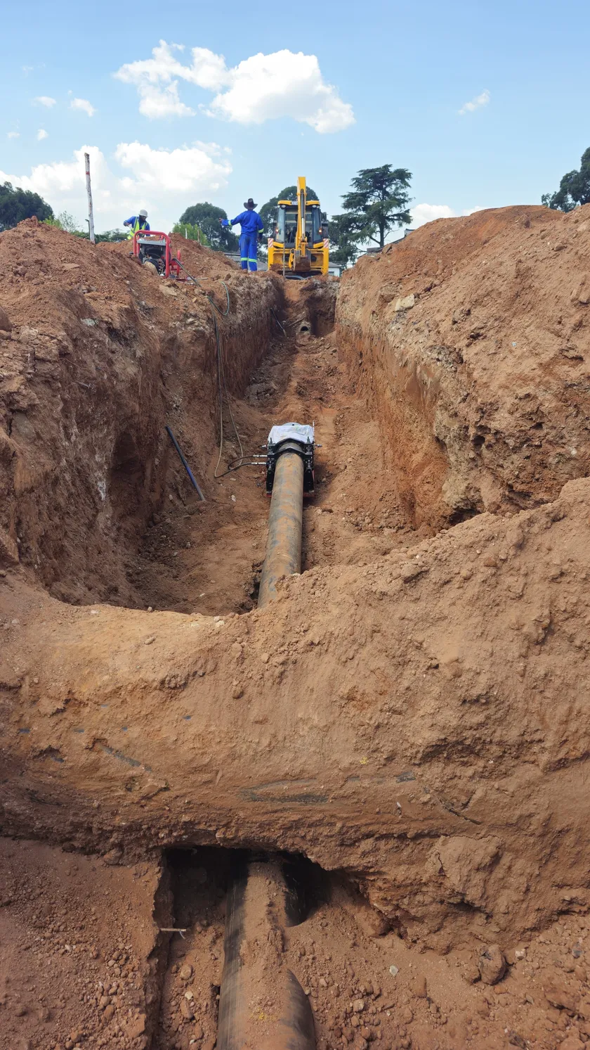 Deep entry/exit pit showing pipe being pulled through HDD bore